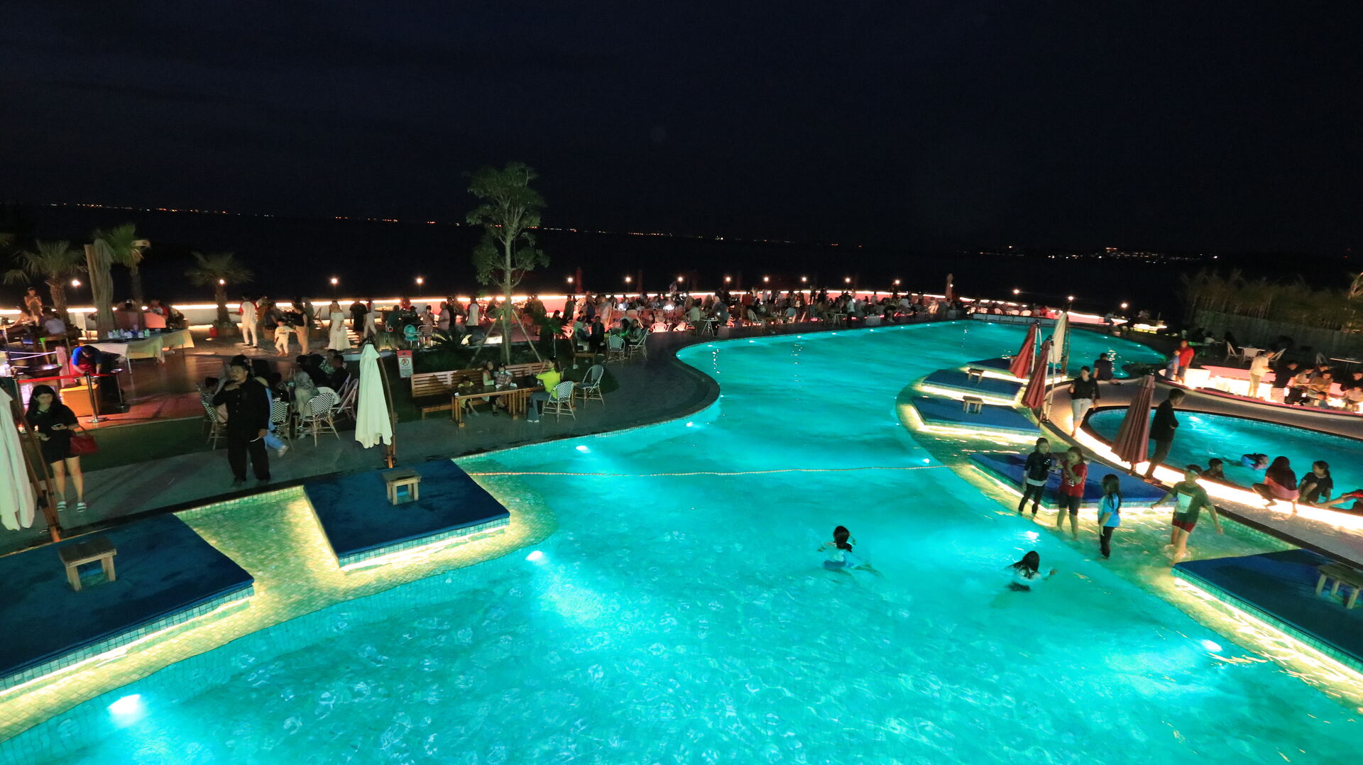 Suasana kolam menyala saat malam hari di Blue Fire Beach Club