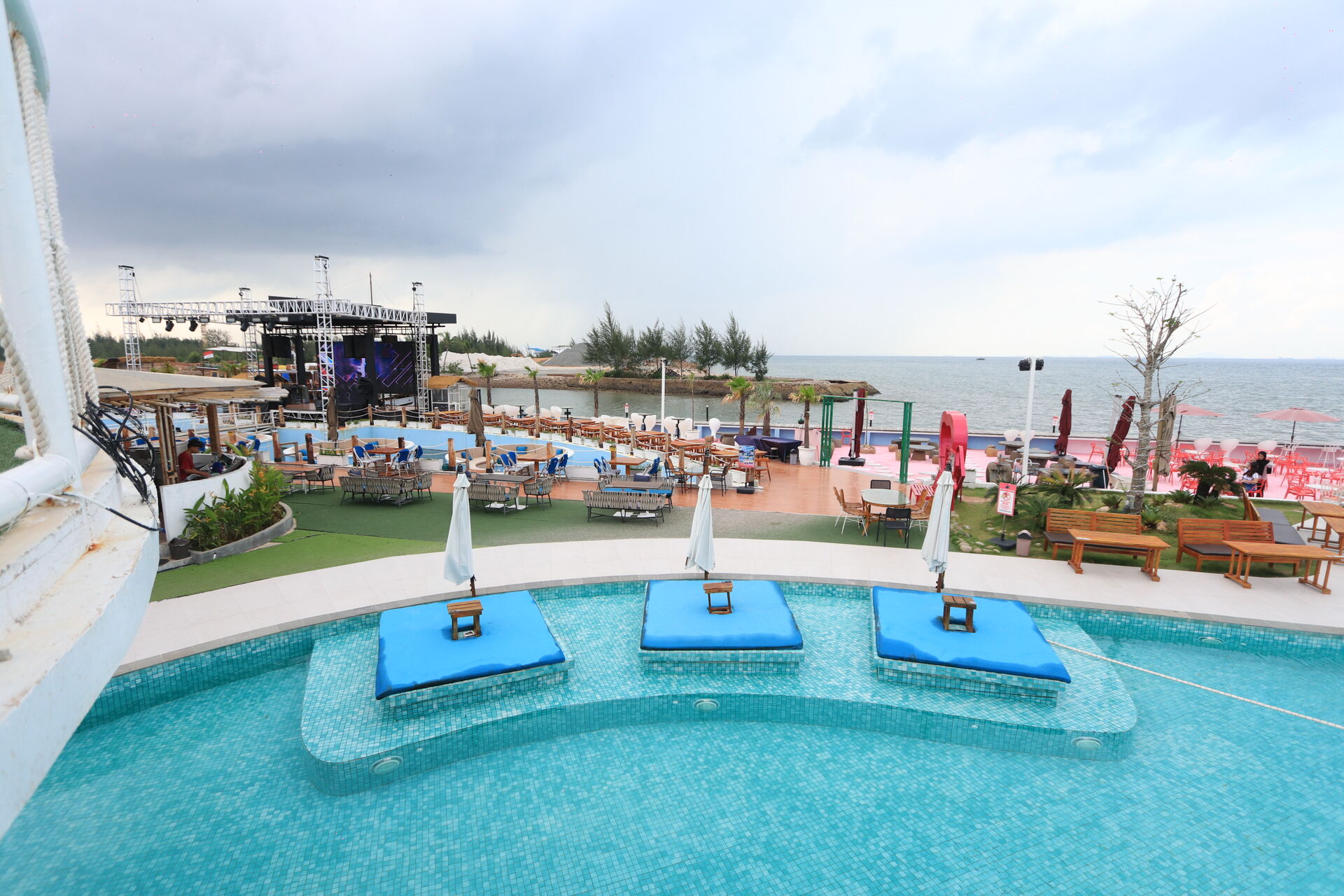 Kolam renang dan panggung utama Blue Fire Beach Club di siang hari